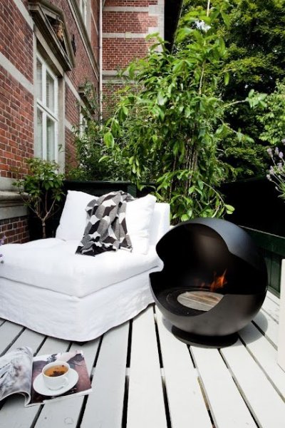 Fancy-and-stylish-design-outdoor-decor-small-terrace-with-white-lounger-and-black-modern-design-garden-decor-firepit-on-white-wooden-deck